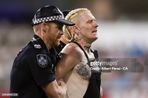 Pitch invader is removed by police during the Big Bash League match between the Brisbane Heat and the Melbourne Renegades at The Gabba on January 10,...