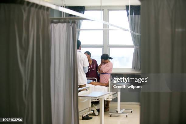 doctor sharing bad news with family member - black curtain stock pictures, royalty-free photos & images