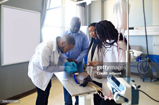 在醫學院學習假肢的年輕醫生小組 - iv going into an arm 個照片及圖片檔