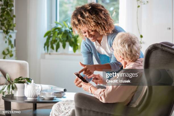 friendly nurse supporting of senior woman - digital health display stock pictures, royalty-free photos & images