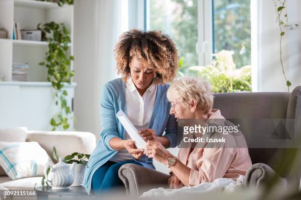 huis verpleegkundige verzorgen van senior vrouw - caregiver and senior stockfoto's en -beelden
