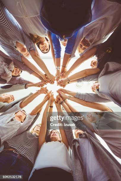 equipo de mujeres agarrados de la mano - union fotografías e imágenes de stock