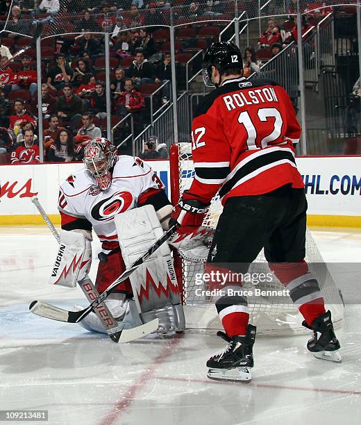 Cam Ward of the Carolina Hurricanes makes a pad save as Brian Rolston of the New Jersey Devils looks for a rebound at the Prudential Center on...