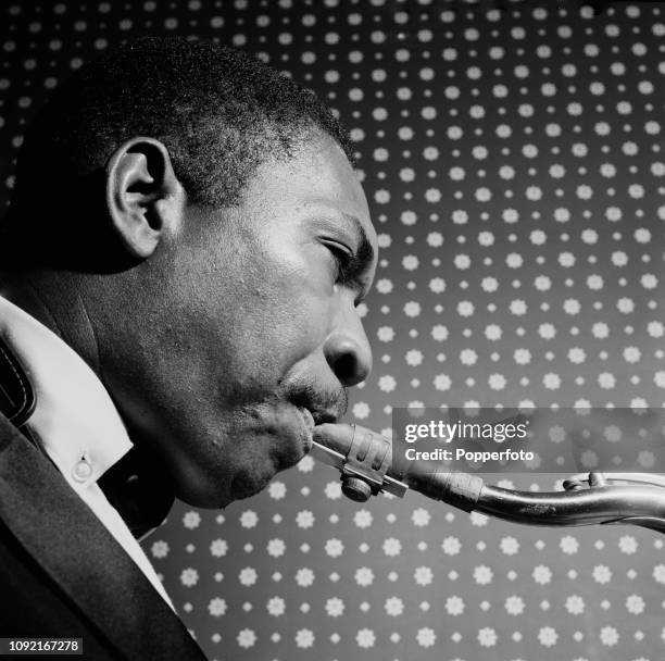 American jazz saxophononist, composer and musician John Coltrane pictured rehearsing backstage prior to performing at a venue in London in November...