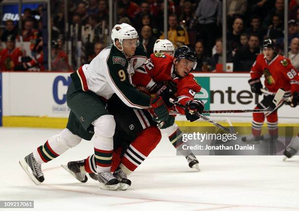 Tomas Kopecky of the Chicago Blackhawks fires a shot under pressure from Mikko Koivu of the Minnesota Wild at the United Center on February 16, 2011...