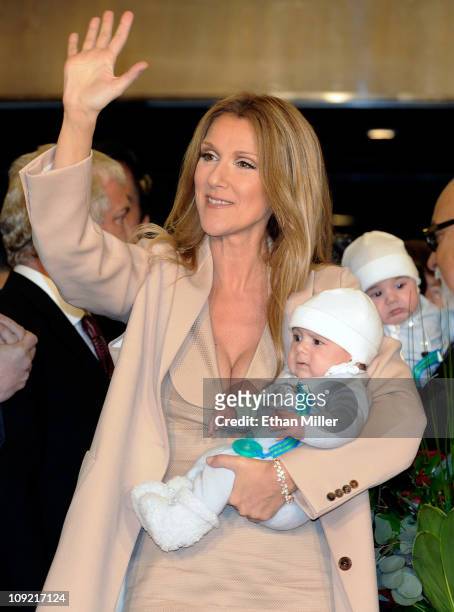 Singer Celine Dion waves as she holds her son Nelson Angelil, with his twin Eddy Angelil in the background, as she arrives at Caesars Palace February...
