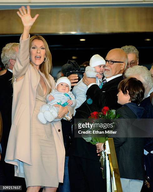 Singer Celine Dion waves as she holds her son Nelson Angelil next to her husband and manager Rene Angelil, holding their son Eddy Angelil, and their...