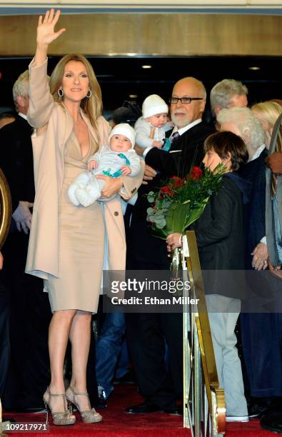 Singer Celine Dion waves as she holds her son Nelson Angelil next to her husband and manager Rene Angelil, holding their son Eddy Angelil, and their...