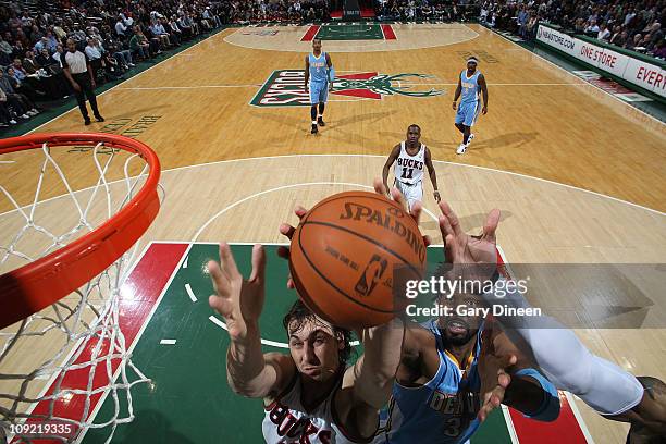 Andrew Bogut of the Milwaukee Bucks reaches for a rebound against Nene of the Denver Nuggets during the NBA game on February 16, 2011 at the Bradley...