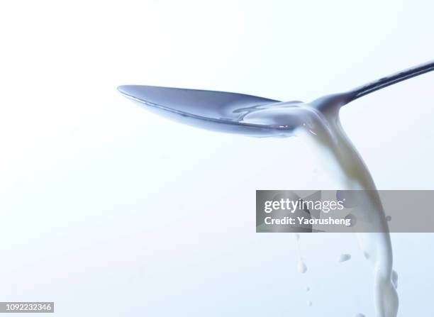 a spoon of milk - milk stream stock pictures, royalty-free photos & images