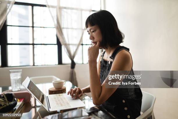 filipino woman working on desk - beauty editor stock pictures, royalty-free photos & images