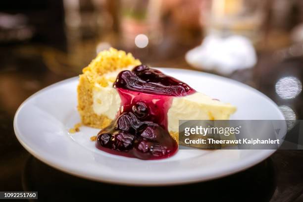 slice of blueberry cheesecake on a plate - cheesecake stock-fotos und bilder