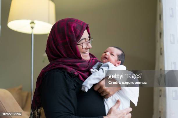 grandmother holding newborn baby boy - west asia stock pictures, royalty-free photos & images