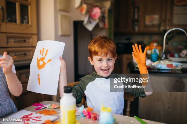 little boy and his hand print painting - child's drawing stock pictures, royalty-free photos & images