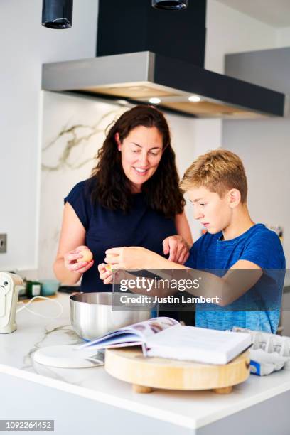 mother and son spending time together baking a cake at home - saltdean stock pictures, royalty-free photos & images