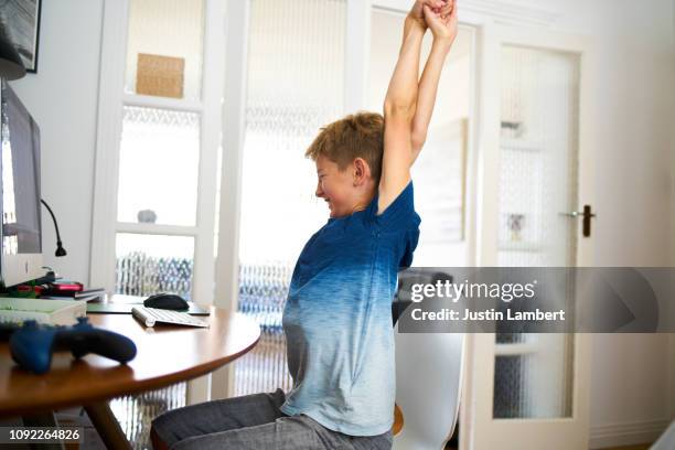 teenager stretching while sitting at the computer for a long time having a rest - saltdean stock pictures, royalty-free photos & images