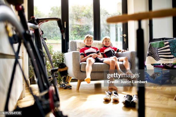 brothers sitting smiling on a couch together before a bike ride - saltdean stock pictures, royalty-free photos & images