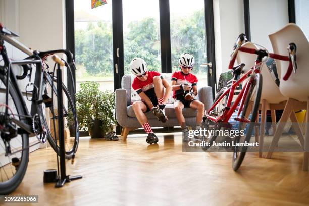 siblings put their shoes on getting ready for a bike ride - saltdean stock pictures, royalty-free photos & images