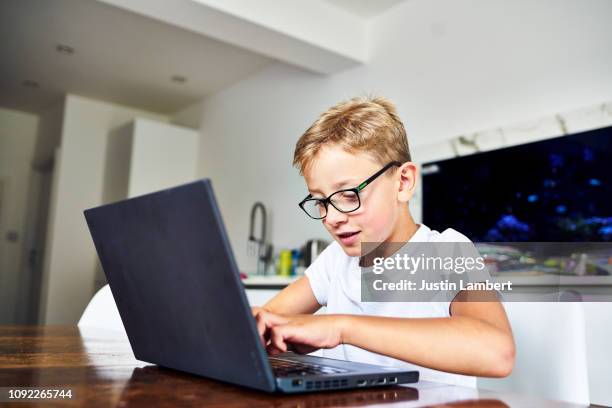 child using a laptop computer at the kitchen table - saltdean stock pictures, royalty-free photos & images