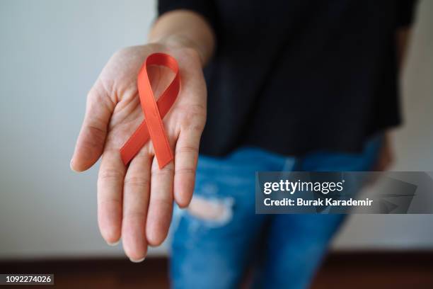 young woman with red aids awareness ribbon - aids virus stock pictures, royalty-free photos & images