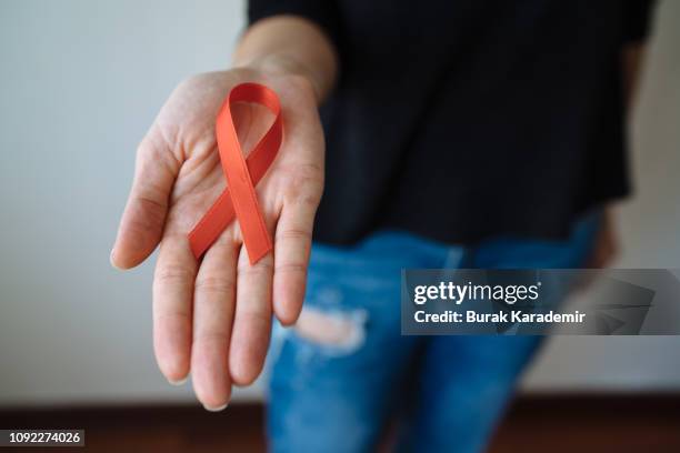 young woman with red aids awareness ribbon - aids stock pictures, royalty-free photos & images