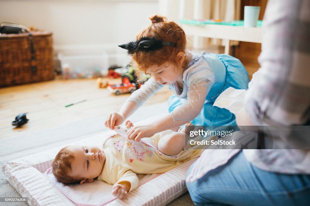 Helping To Change Her Baby Sisters Diaper High Res Stock Photo Getty helping-to-change-her-baby-sisters-diaper-high-res-stock-photo-getty