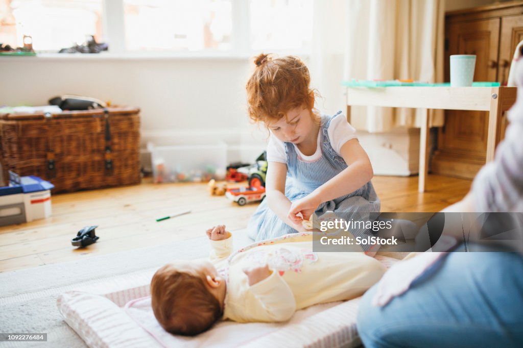 Changing Her Baby Sisters Diaper High Res Stock Photo Getty Images changing-her-baby-sisters-diaper-high-res-stock-photo-getty-images
