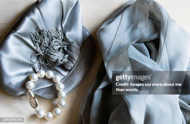 a close up of a cluth, a pearl bracelet and a shalw. still life. - clutch bag stock pictures, royalty-free photos & images