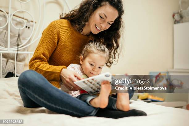 мother and daughter reading fairy tales - supermom stock pictures, royalty-free photos & images