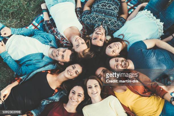 cirkel van vrienden - lying down stockfoto's en -beelden