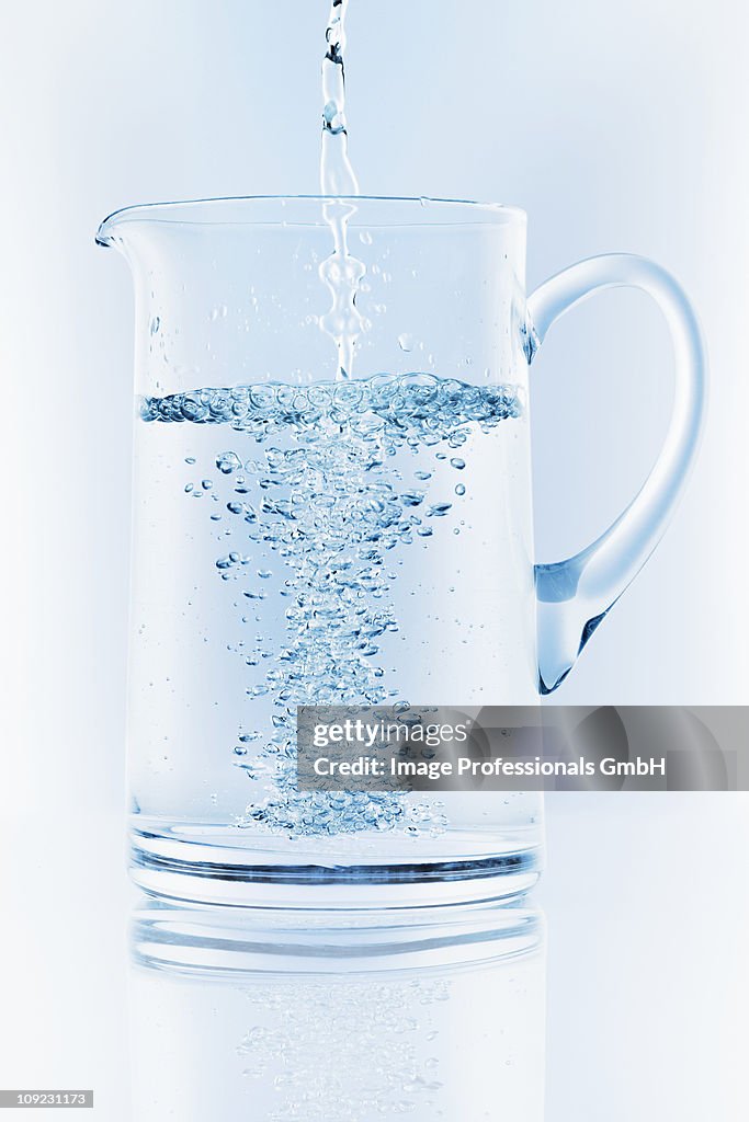 Water being poured into jug, close-up