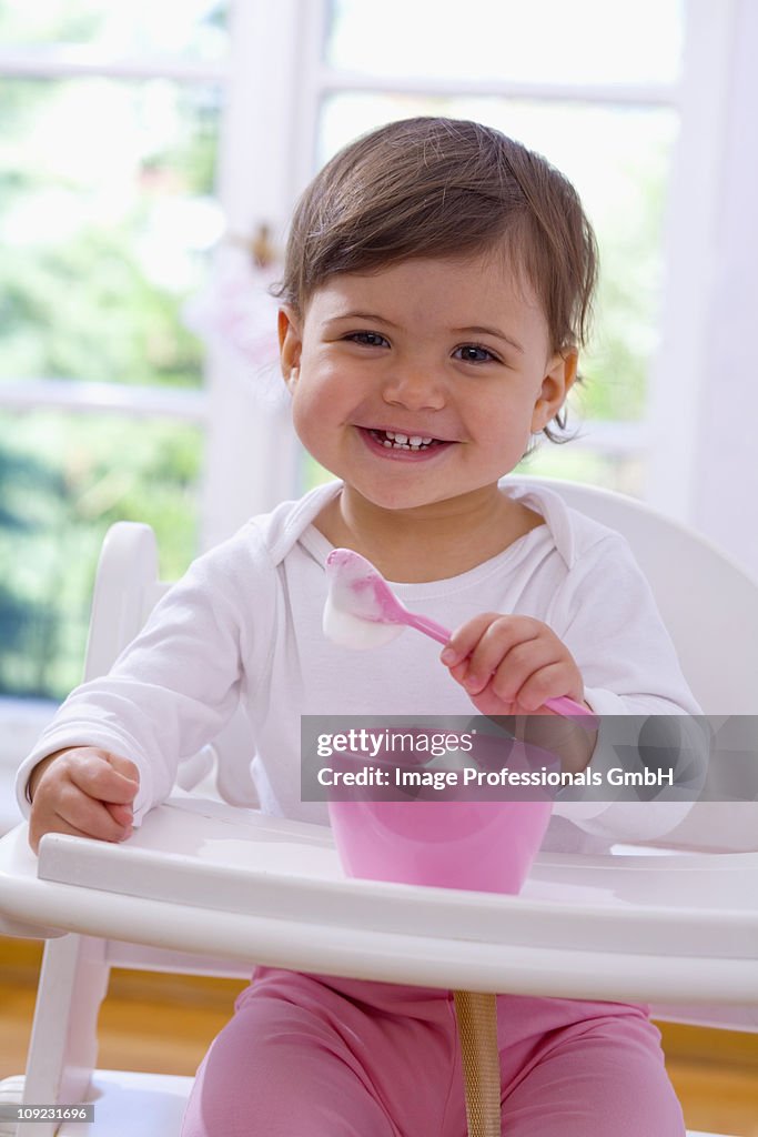 Baby girl (18-23 Months) eating milk froth, close-up