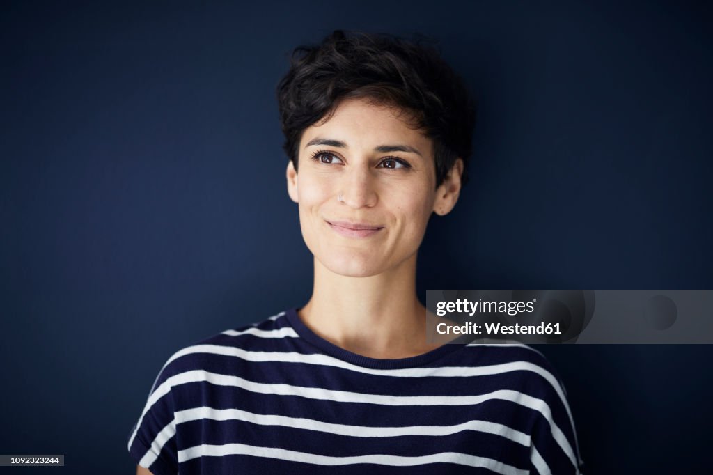 Portrait of smiling woman at blue wall