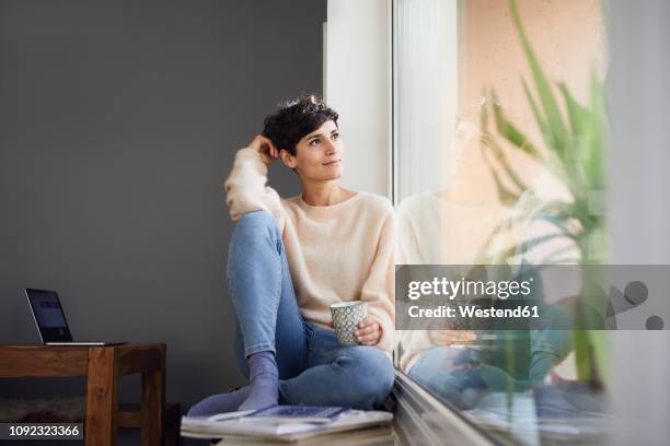 relaxed woman at home sitting at the window - windowsill copy space stock pictures, royalty-free photos & images