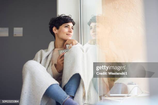 relaxed woman at home sitting at the window - winter relaxation stock pictures, royalty-free photos & images