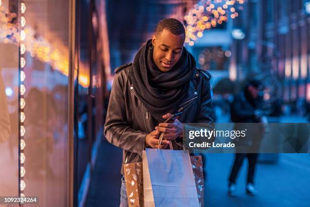 schöner schwarzer mann beim weihnachts-shopping - amsterdam noel stock-fotos und bilder