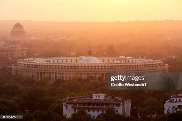 india, delhi, new delhi, parliament building at sunset, pollution, smog - indian politics and governance stock pictures, royalty-free photos & images