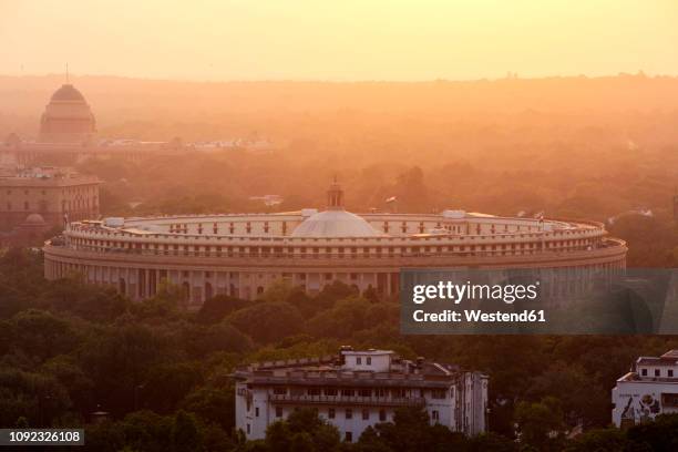 india, delhi, new delhi, parliament building at sunset, pollution, smog - parliament india stock pictures, royalty-free photos & images