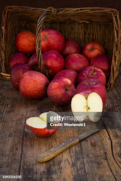 red apples in basket, knife and halved on wood - gala apples stock pictures, royalty-free photos & images