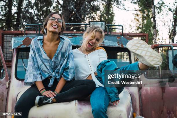 friends sitting on a broken truck, having fun - oproer stockfoto's en -beelden