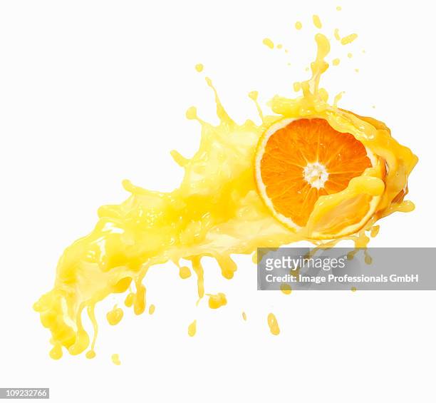 orange juice splashing on orange against white background - orange juice stock pictures, royalty-free photos & images