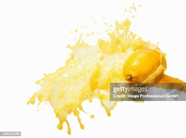 lemon juice splashing on lemon - lemon juice stock pictures, royalty-free photos & images