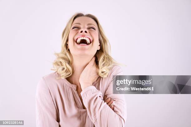 portrait of laughing blond woman leaning back - women laughing fotografías e imágenes de stock