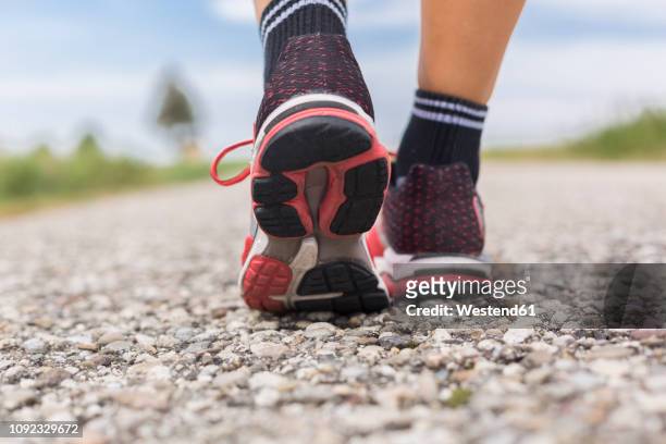 feet of sportive woman on country lane in summer - sole of shoe stock-fotos und bilder