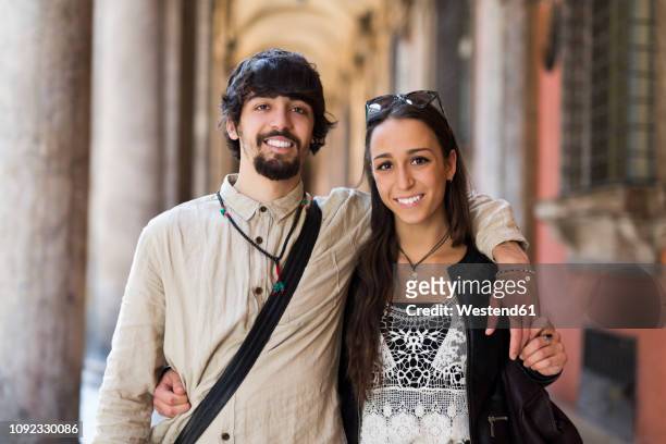 italy, bologfna, portrait of happy young couple arm in arm - bologna italy stock pictures, royalty-free photos & images