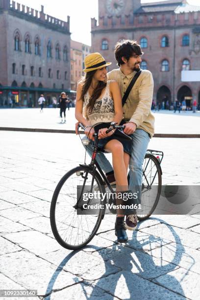 italy, bologna, young couple on bicycle watching something - bologna italy stock pictures, royalty-free photos & images