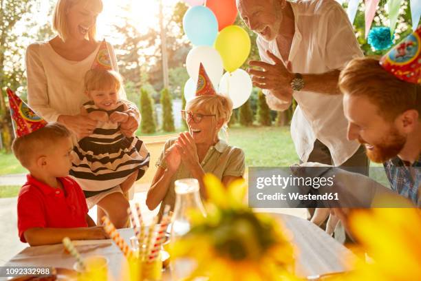 happy extended family on a garden birthday party - older woman birthday stock pictures, royalty-free photos & images