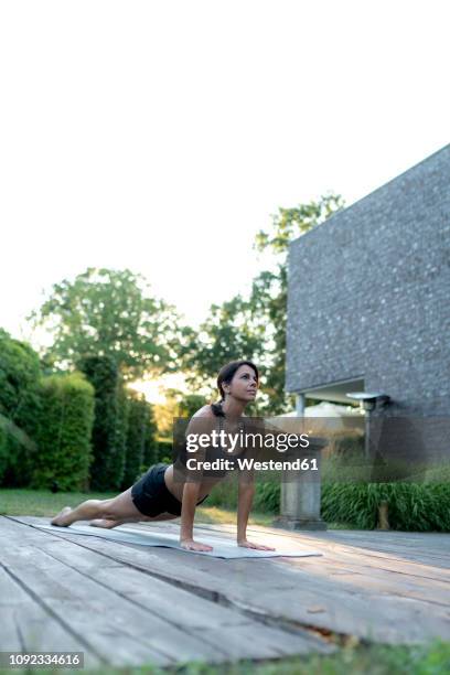 woman practicing yoga in garden - turner contemporary stock-fotos und bilder