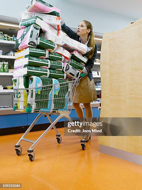 young woman with shopping cart - shopping humor stock pictures, royalty-free photos & images