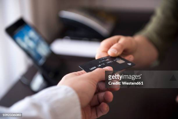 handing over credit card - credit card stock-fotos und bilder